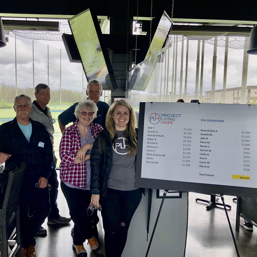 A team of people at work looking over at a coworker's work