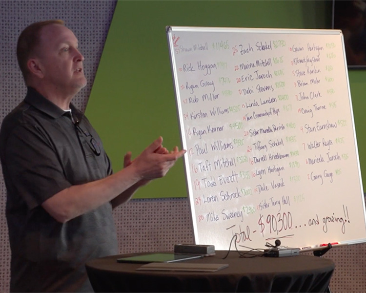 A team of people at work looking over at a coworker's work